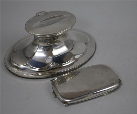 An oval silver inkwell with fluted decoration and a slim silver pendant cigarette case